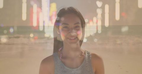 Smiling asian woman on dreamy double-exposure beach with city bokeh lights at sunset