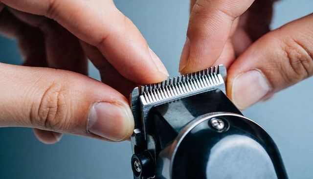Adjusting electric hair clipper blade with fingers for precision grooming and maintenance
