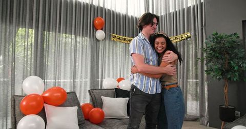 Happy Couple Embracing at Birthday Celebration in Modern Living Room