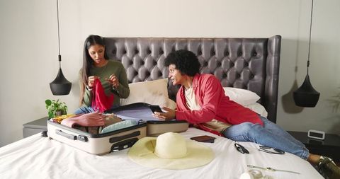 Diverse Couple Packing Suitcase for Vacation Adventure