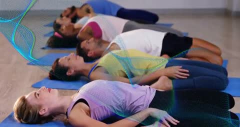 Group lying in savasana following animated breathing cue for guided yoga cooldown and breathwork
