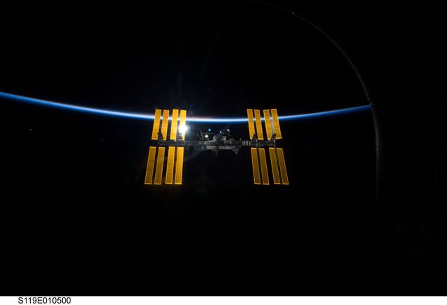 Image of the International Space Station as seen from Space Shuttle Discovery after separation showing the blackness of space and Earth's thin atmosphere. Ideal for use in articles, educational materials, or media content related to space exploration, NASA missions, technology, and collaborative space programs.