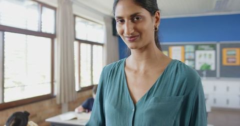 Confident Teacher Smiling in Bright Classroom Environment