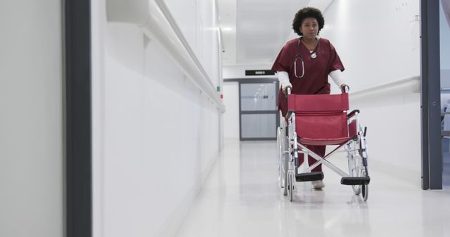 Healthcare professional walking down hospital hallway with wheelchair - Download Free Stock Images Pikwizard.com