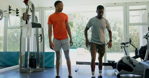 Trainer Guiding Young Man in Fitness Stretch Routine
