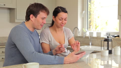 Couple Enjoying Time With Tablet in Modern Kitchen