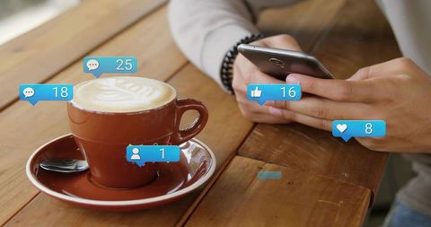 Man Engaging with Smartphone while Sipping Coffee