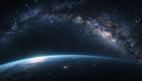Earth limb with twilight glow and milky way arch from orbit, city lights and deep space