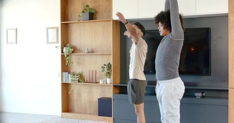 Diverse Male Friends Exercising Together in Modern Living Room