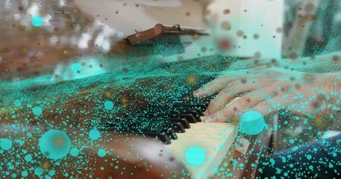 Pianist hands on grand piano blending with turquoise particles