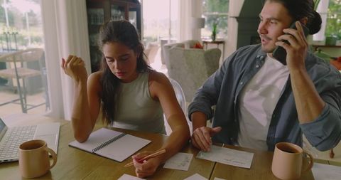 Couple Planning Wedding Together at Home with Notes and Discussions