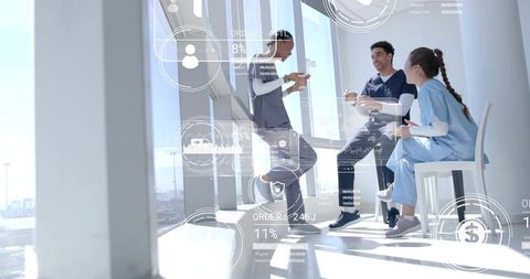 Healthcare professionals collaborating with digital data in sunny breakroom