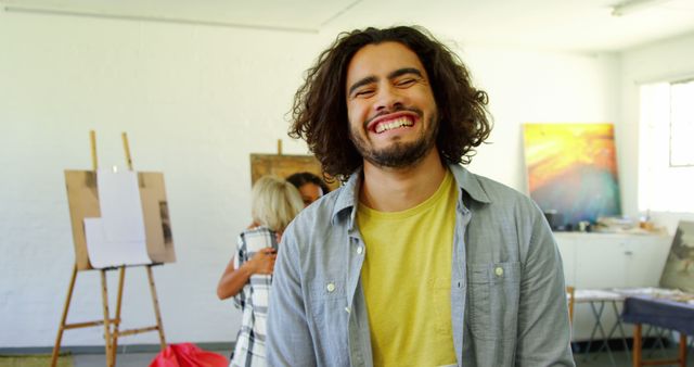 Happy Young Man Smiling in Art Studio with Couple in Background - Download Free Stock Images Pikwizard.com
