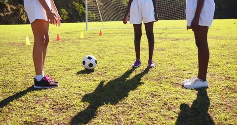 Diverse Young Soccer Players on Field with Ball