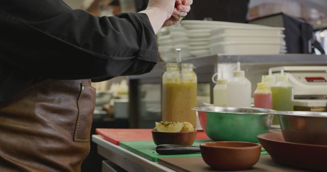 Chef Wearing Apron Seasoning Dish in Restaurant Kitchen - Download Free Stock Images Pikwizard.com