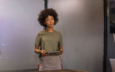 African american businesswoman standing with tablet presenting in modern glass office