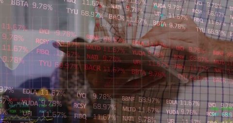 Colleagues comparing mobile data with stock market tickers overlay for financial analysis