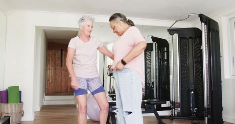 Senior lesbian couple enjoying fitness together at home gym