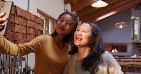 Diverse Mother and Daughter Taking Selfie in Cozy Kitchen