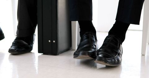 Business professionals nervously shaking feet in office setting
