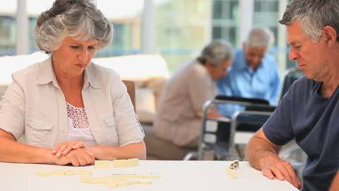 Elderly Couple Engaged in Relaxing Game of Dominos