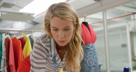 Young designer focused on fabrics in fashion studio