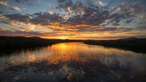 Idyllic sunset over serene nebraska river with vibrant sky reflections