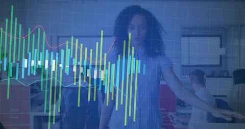 Presenter pointing at interactive data dashboard with teal charts in open-plan office