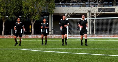 Soccer Players Warming Up with High Knees in Black Uniforms
