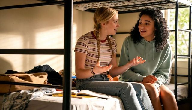 Teen friends chatting on dorm bunk bed while studying and sharing journal in daylight