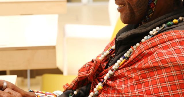 This close-up shows an elder wearing colorful traditional attire and beaded accessories, emblematic of cultural heritage. Great for use in articles about African tribal communities, cultural heritage, traditions, or diversity. It can also be used in social projects, educational materials, and cultural awareness campaigns.