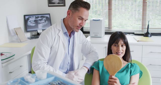 Woman at Dental Appointment with Dentist Holding Mirror - Download Free Stock Images Pikwizard.com