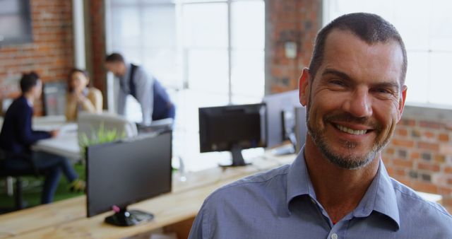 Smiling Businessman Posing in Modern Open Office - Download Free Stock Images Pikwizard.com