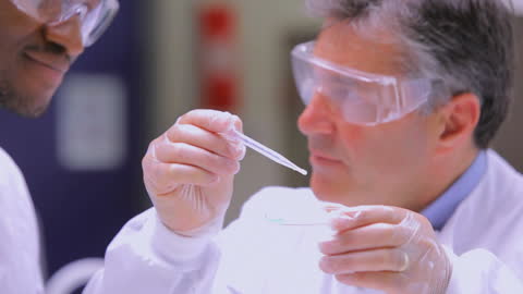 Scientists Experimenting With Liquid Chemicals in Modern Laboratory