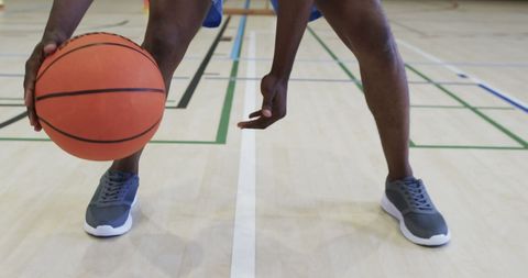 Closeup of basketball player dribbling on indoor court