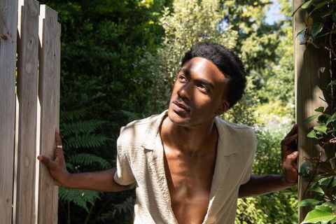 Man exploring bright garden sunlight scene surrounded by lush greenery