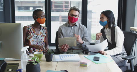 Diverse Business Team Collaborating on Tablet in Modern Office