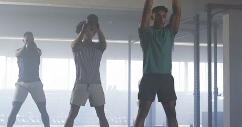 Men Performing Kettlebell Exercises in Modern Gym