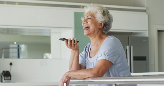 African american senior woman smiling while talking on smartphone at home. retirement senior lifestyle living in quarantine lockdown concept