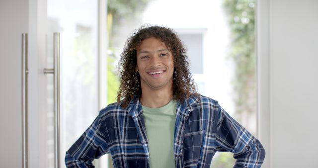 Portrait of happy biracial man with long curly dark hair in doorway at home - Download Free Stock Photos Pikwizard.com