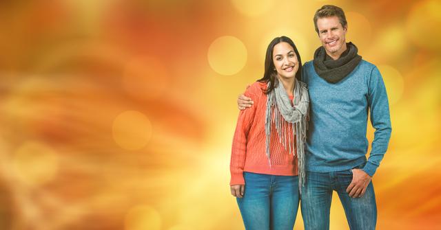 Smiling couple dressed in casual autumn clothing, posing together with vibrant bokeh background. This could be used for fall season promotions, lifestyle blog posts, seasonal greetings, or fashion advertisements.