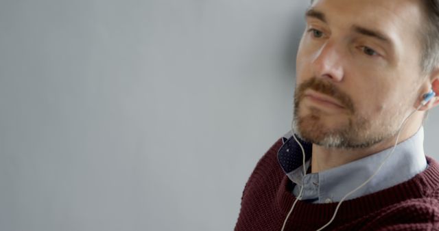 Close-Up of Thoughtful Man Listening to Music on Earphones - Download Free Stock Images Pikwizard.com