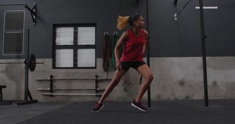 African american woman performing side lunge in urban gym