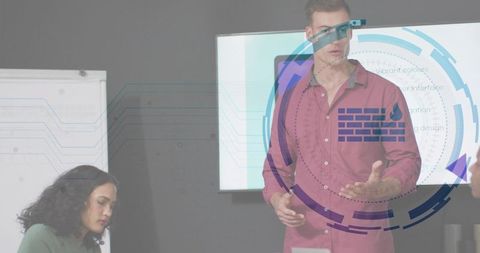 Presenter gesturing with digital HUD overlay while coworker taking notes in boardroom meeting