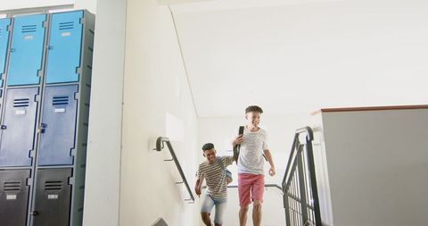 Diverse High School Students Descending Staircase Bright Hallway