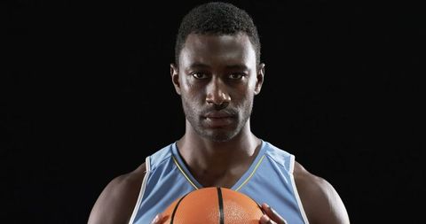 Basketball Player Holding Ball with Determined Focus