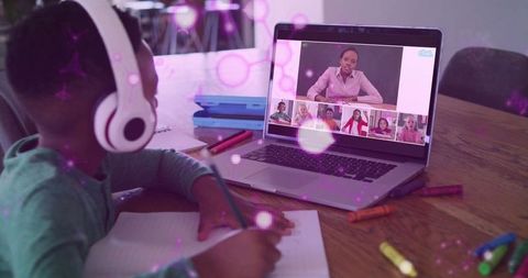 Child engaged in virtual classroom with laptop and headphones
