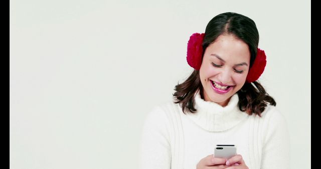 Young Woman Wearing Red Earmuffs Smiling at Her Phone - Download Free Stock Images Pikwizard.com