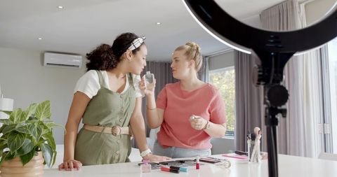 Diverse female friends reviewing skincare product at home studio