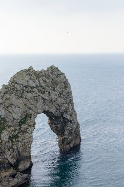 Rock Formation Arch By Tranquil Seaside During Day - Download Free Stock Photos Pikwizard.com